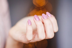 Woman's hand with pink acrylic nail polish